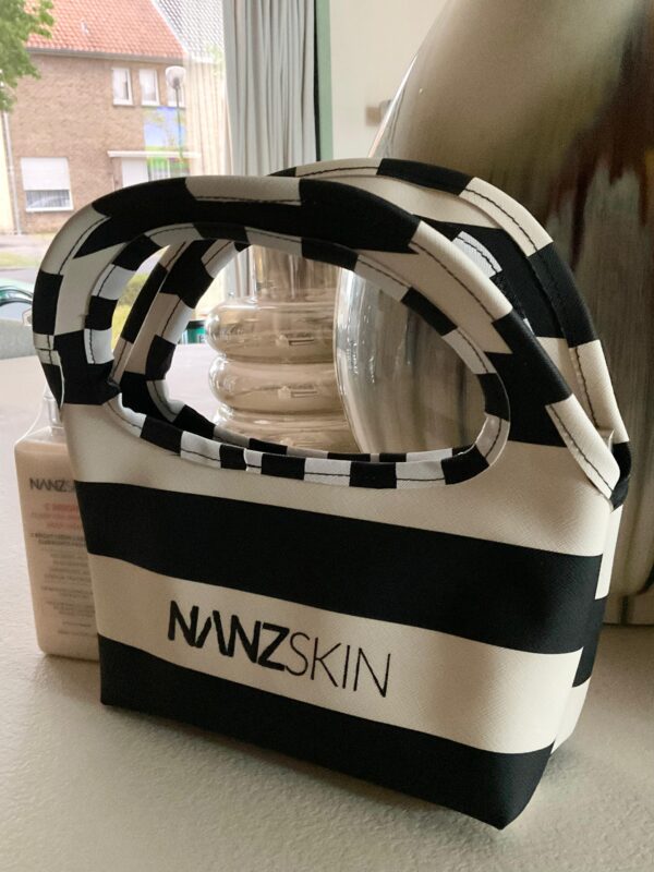 The Nanzskin Riviera Pouch is a sleek, architecturally inspired beauty  companion, designed for the discerning skincare lover. Crafted in signature  black and white neoprene with a sculptural checkered handle, it’s perfect  for housing your Nanzskin essentials, whether on your vanity, in your tote,  or by your side while traveling. Lightweight, structured, and unmistakably  bold, the Riviera Pouch is elegance in motion. 